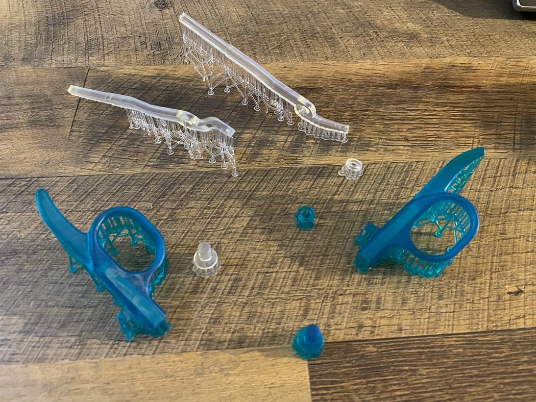 Several printed instrument prototypes in clear and teal resin