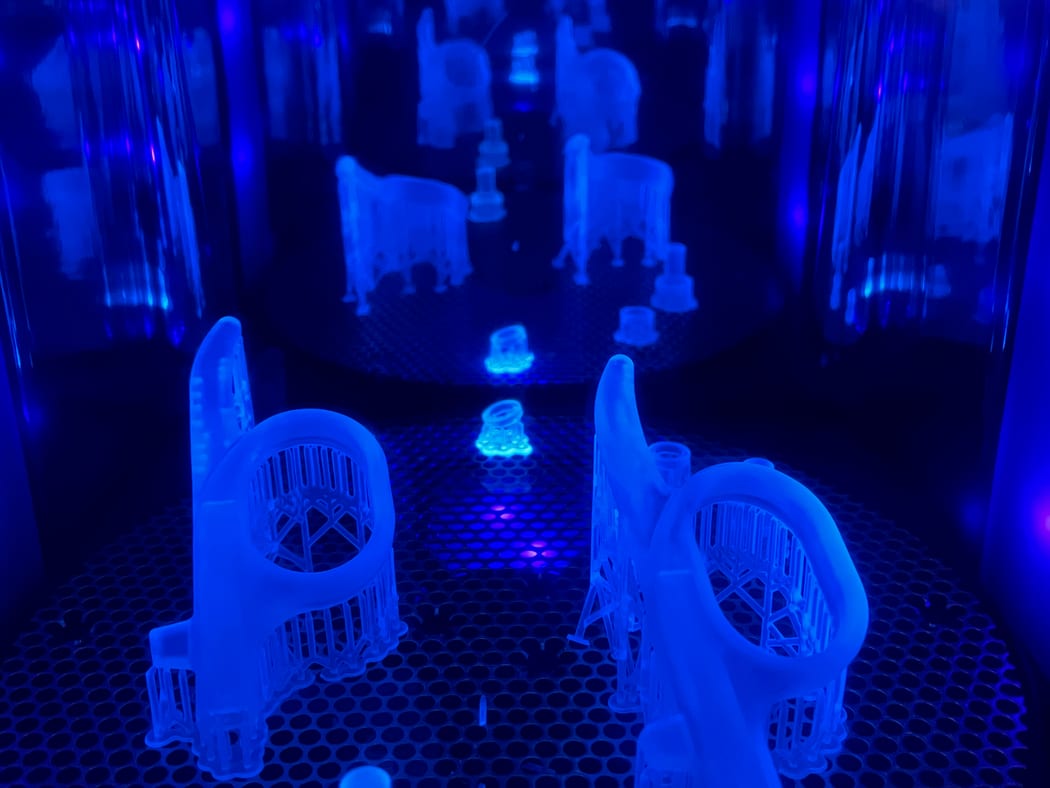 Parts curing under UV light in a resin 3D printer