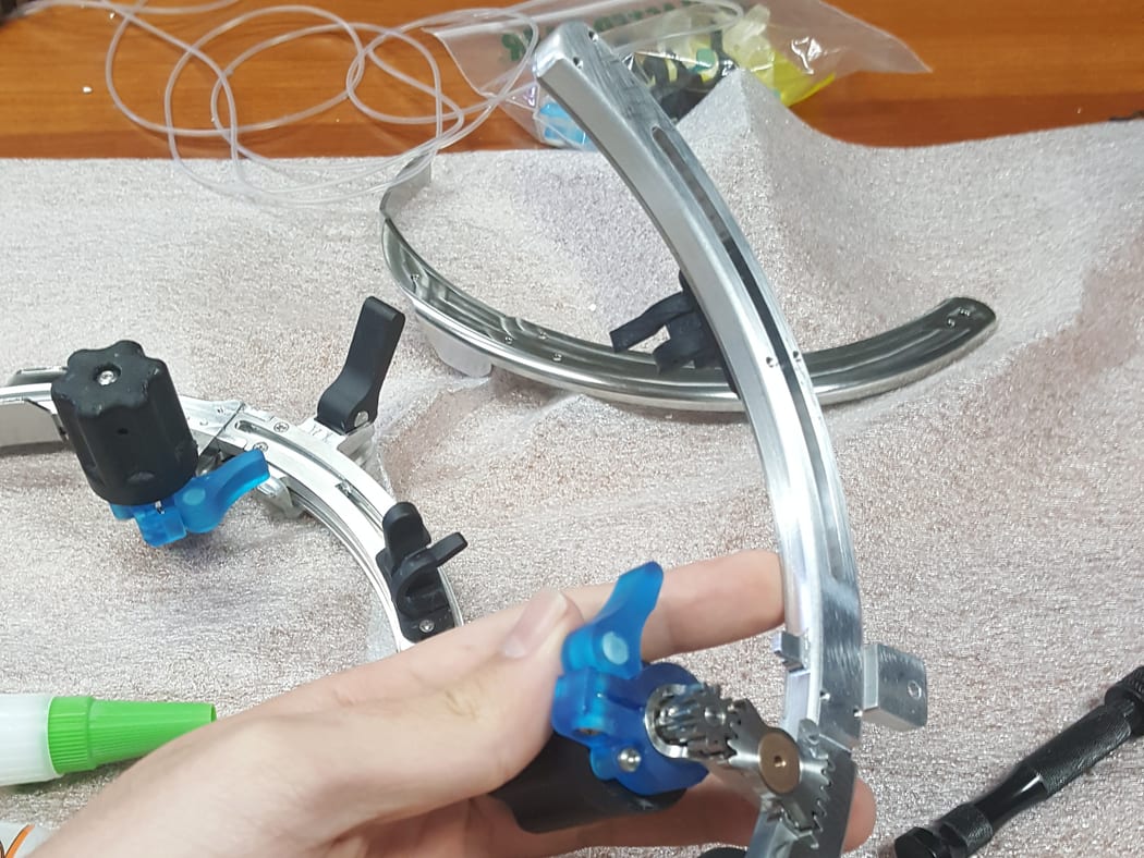 Multi-component stainless surgical device with ratcheting adjustment and quick-release fittings